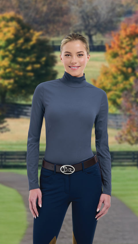 Woman wearing gray turtleneck and dark blue pants in fall setting