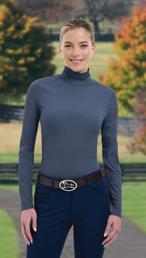 Woman wearing gray turtleneck and dark blue pants in fall setting