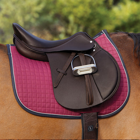 Cropped image of bay horse with a close contact saddle and a burgundy saddle pad with navy piping.